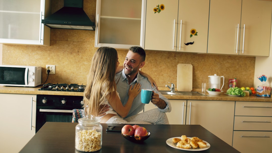 Couple enjoying coffee in a bright kitchen setting.