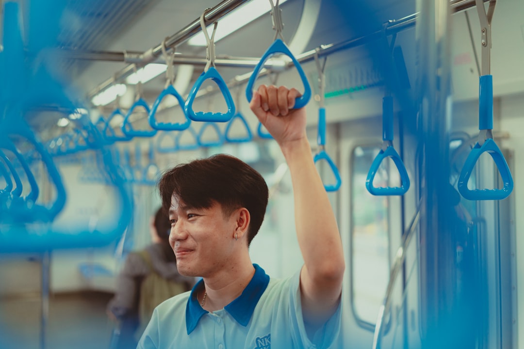 A man in a blue shirt is on a cell phone