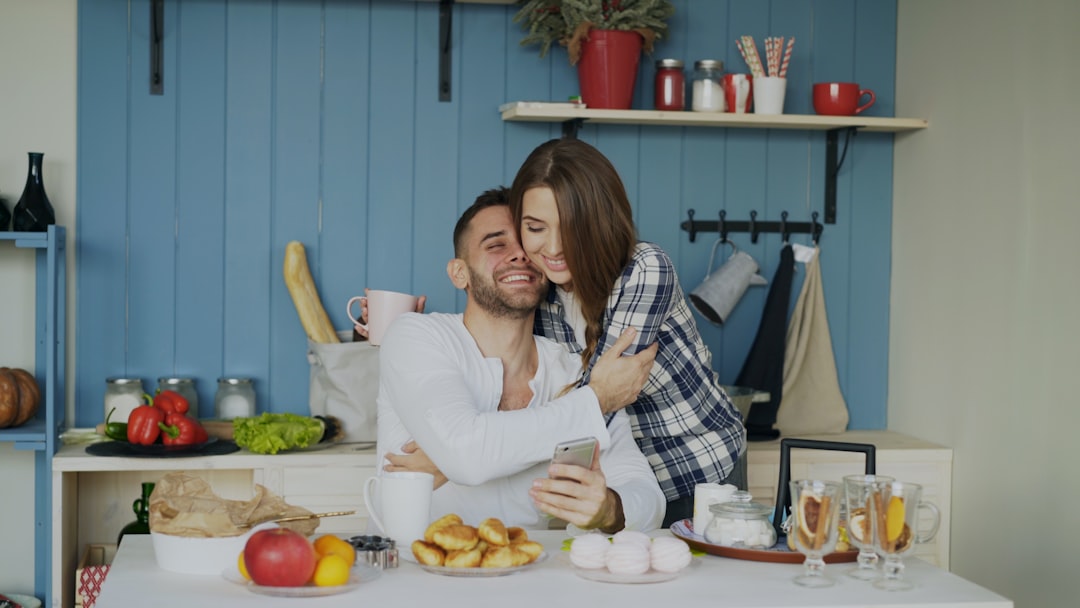 Couple hugging and smiling in a kitchen.