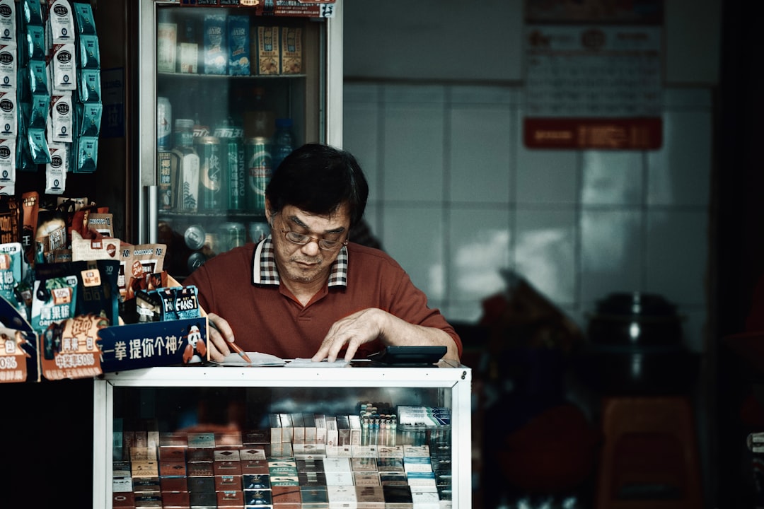 a man sitting at a table looking at a book