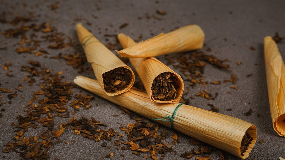 Close-up of rolled tobacco cigars on a textured surface, showcasing rustic natural materials.