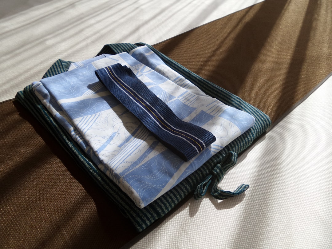 a stack of folded towels sitting on top of a bed