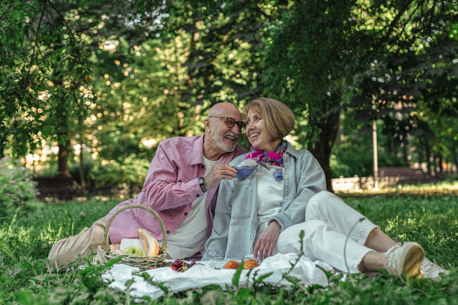 Elderly couple joyfully sharing a picnic in a sunlit park, capturing love and togetherness.