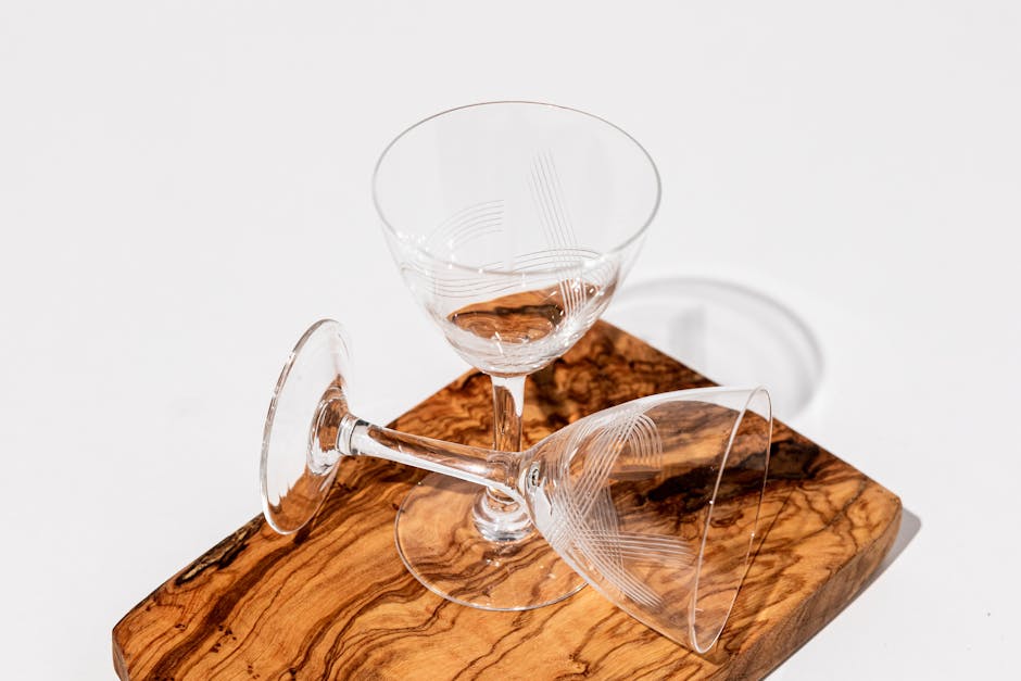 Two empty crystal glasses on a wooden board with a minimalist design, perfect for decor ideas.