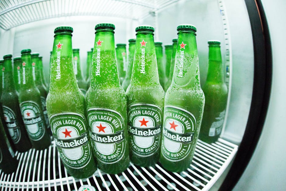 Frosted Heineken beer bottles in a refrigerator showcasing the refreshing coolness.