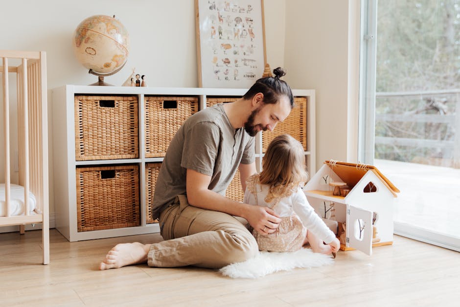 Father and young daughter enjoying quality time with a toy house inside a cozy room.