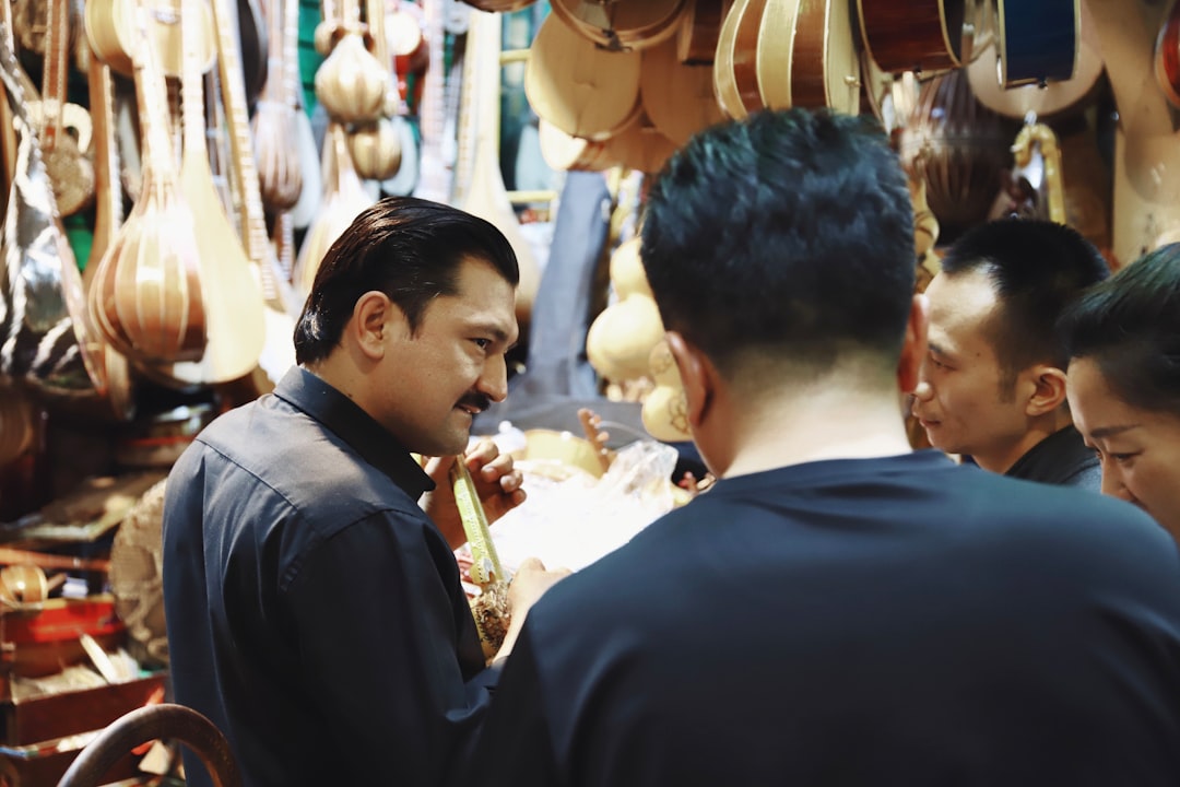 four people standing in front of guitar stall