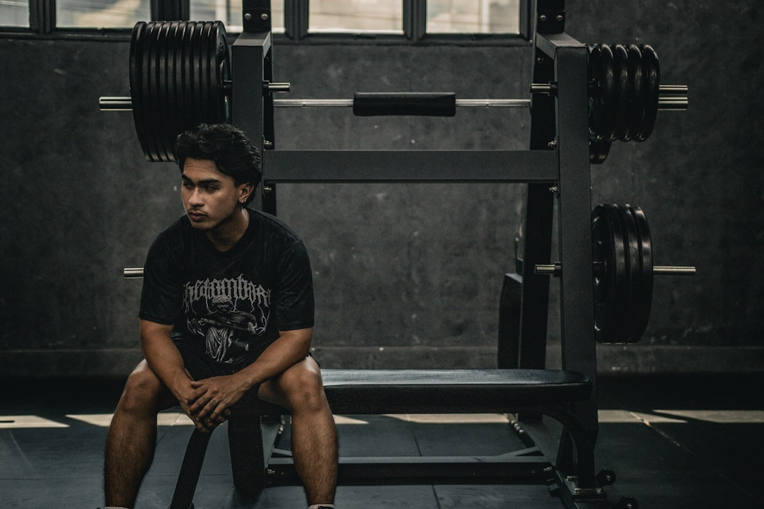 A man sitting on a bench in a gym