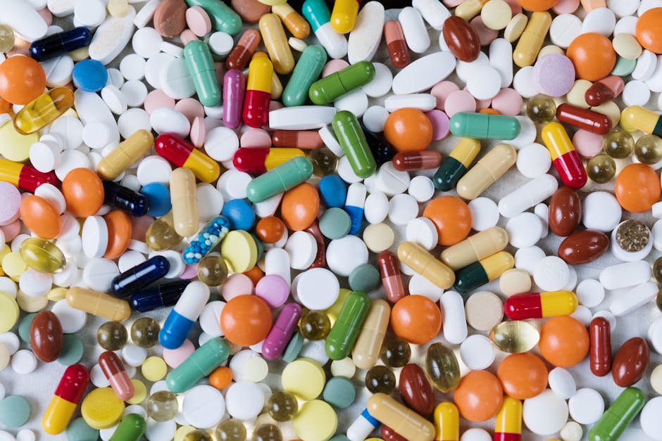 Vibrant assortment of medicine capsules and tablets in a flatlay format, highlighting diversity in pharmaceuticals.