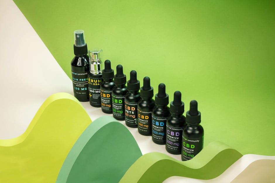 Creative layout of CBD oil bottles with vibrant green backdrop in studio setting.