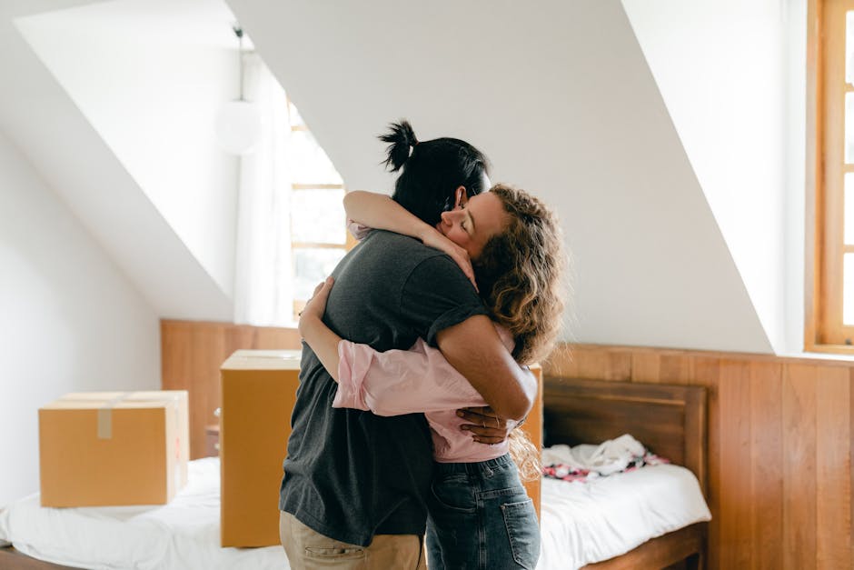 Young couple hugging in their new home, surrounded by boxes, symbolizing a fresh start.